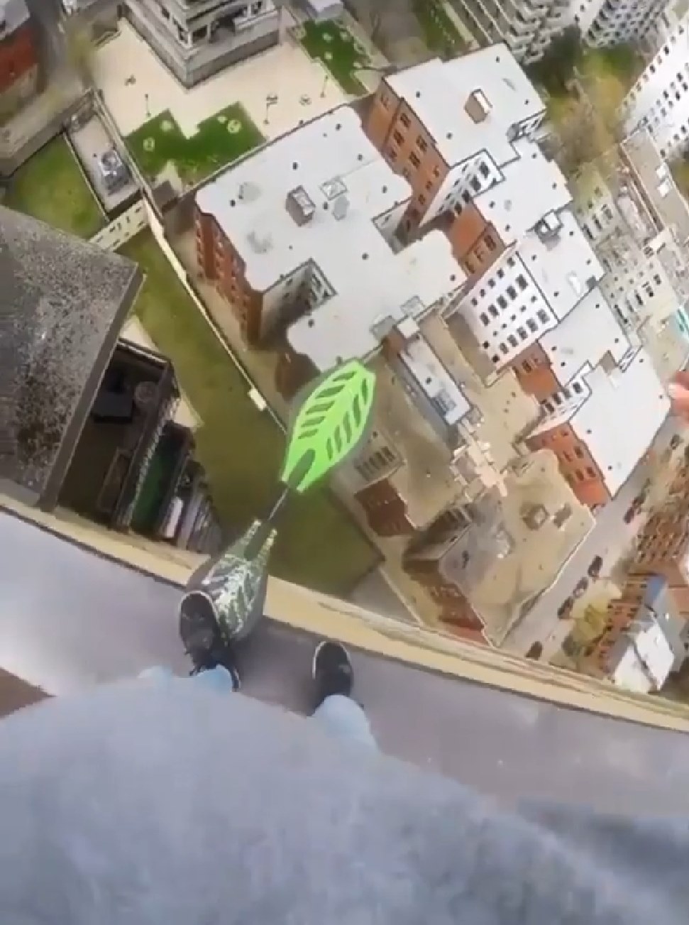 The meme is a screenshot of a person's perspective from the edge of a high building, looking down at the ground below. The text "I'm not crying, I'm just allergic to oxygen" is often overlaid on the image, implying a sense of fear or panic. The image is meant to be humorous and ironic, exaggerating the person's fear of heights.